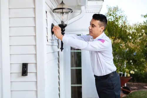 Mister Sparky Tech is working on installing an outdoor light fixture at a Miami home