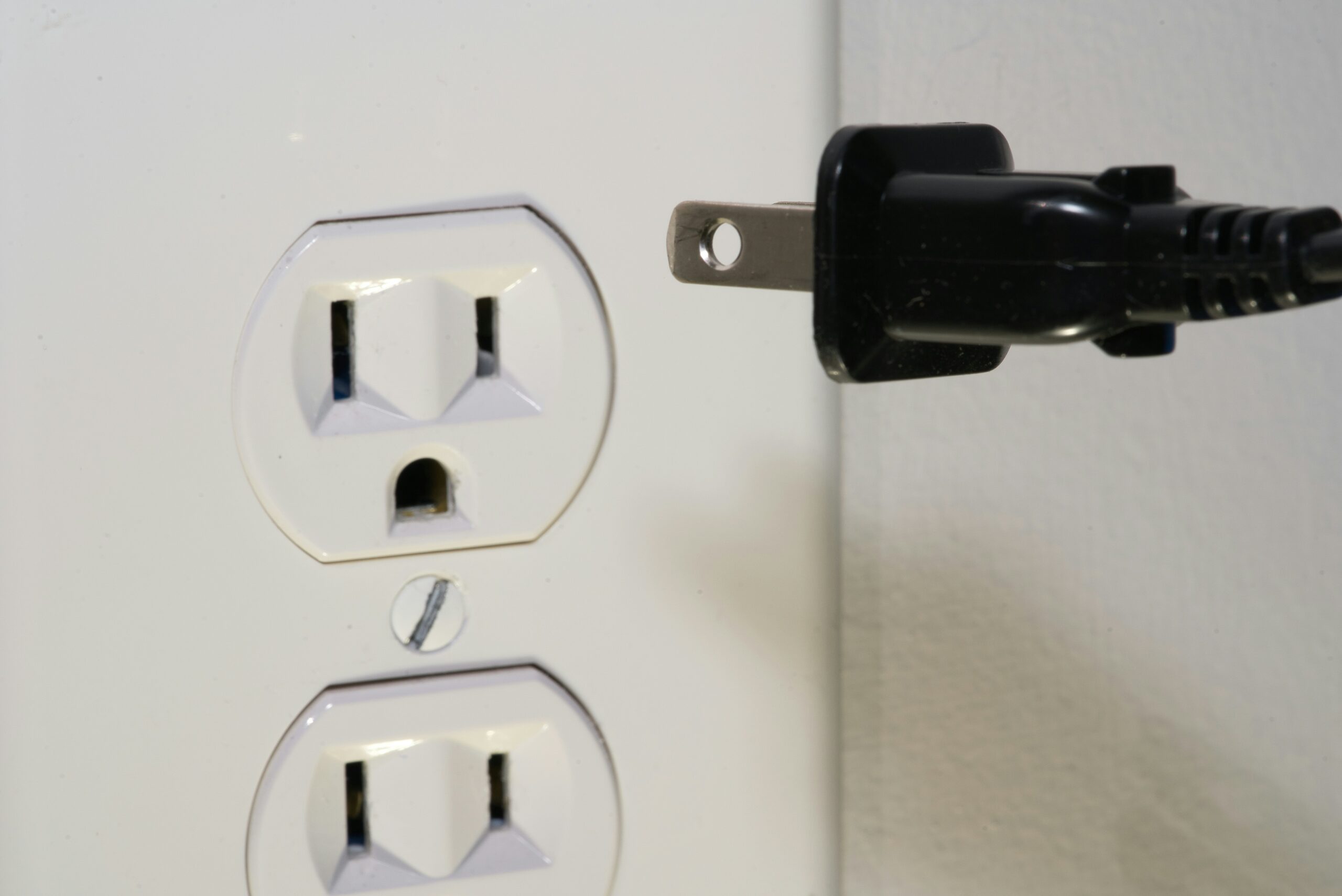 plug being inserted into loose electrical outlet 